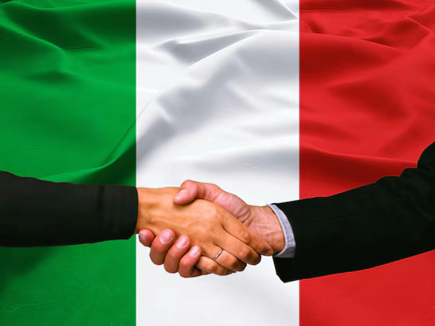 Stisk rok dveh poslovnežev pred italijansko zastavo