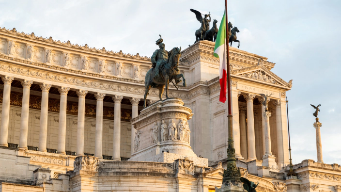 Spomenik Viktorju Emanuelu II. v Rimu z italijansko zastavo v večerni svetlobi