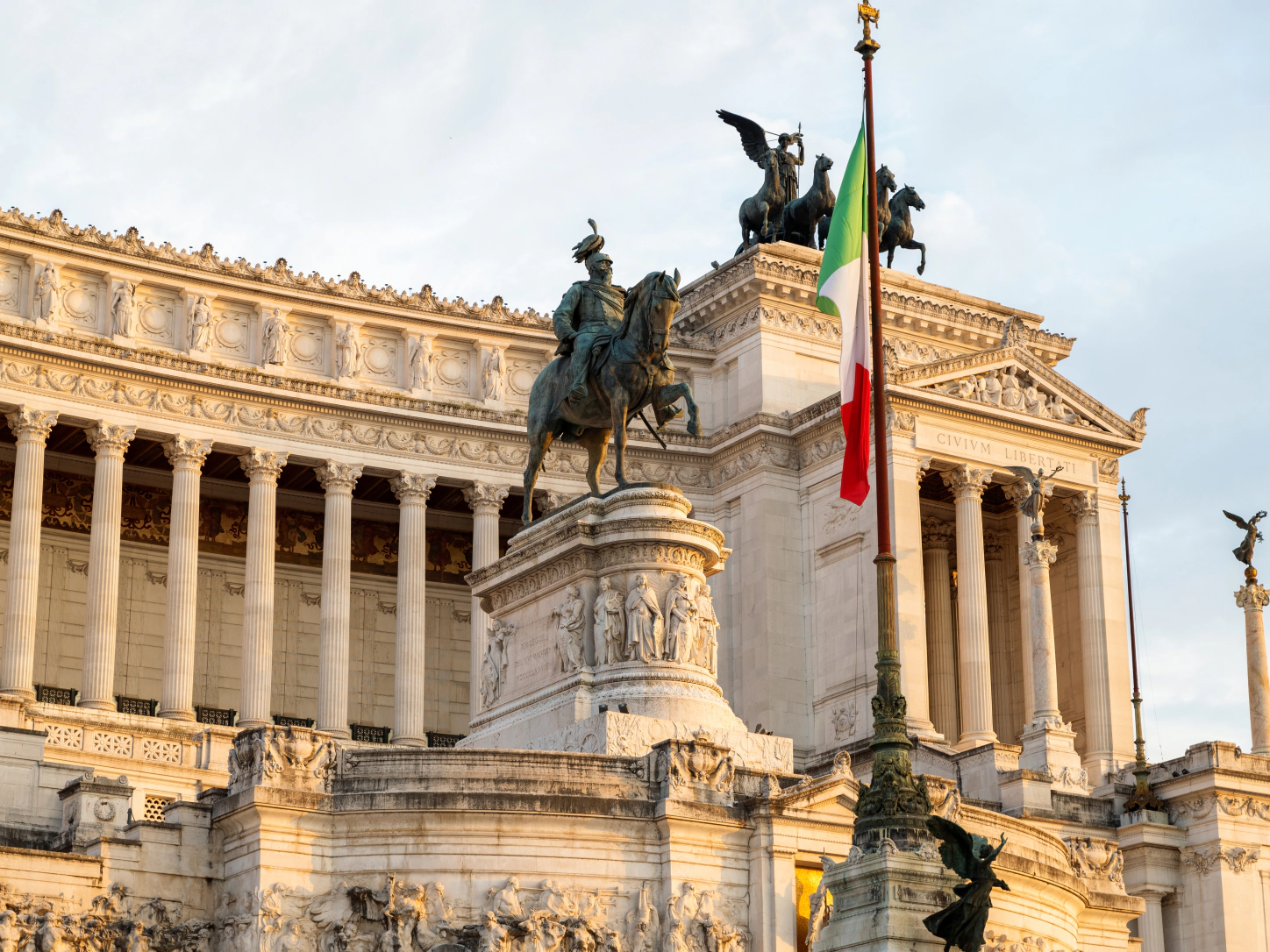 Spomenik Viktorju Emanuelu II. v Rimu z italijansko zastavo v večerni svetlobi